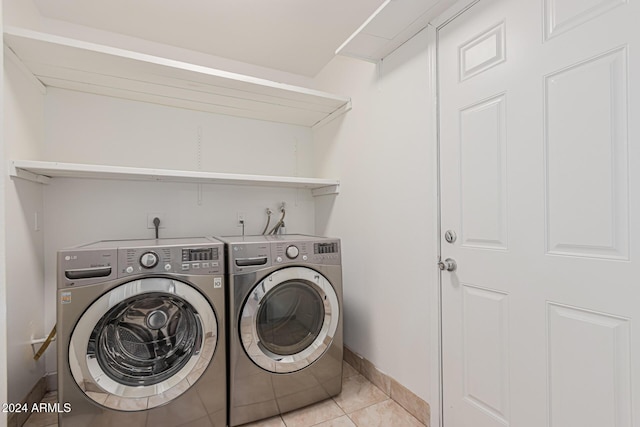 laundry area featuring light tile patterned flooring and washing machine and dryer