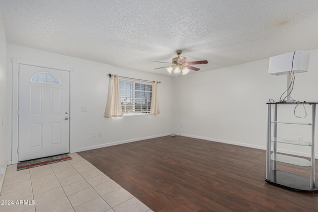 tiled foyer featuring ceiling fan and a textured ceiling