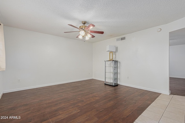 spare room with ceiling fan, wood-type flooring, and a textured ceiling