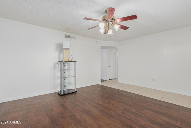 unfurnished room with wood-type flooring, ceiling fan, and a textured ceiling