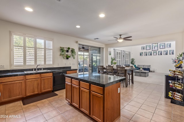 kitchen featuring dishwasher, a kitchen island, sink, and a wealth of natural light