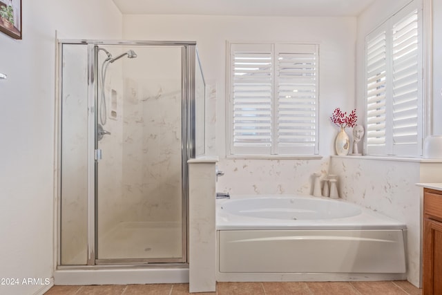 bathroom with tile patterned flooring, vanity, and plus walk in shower