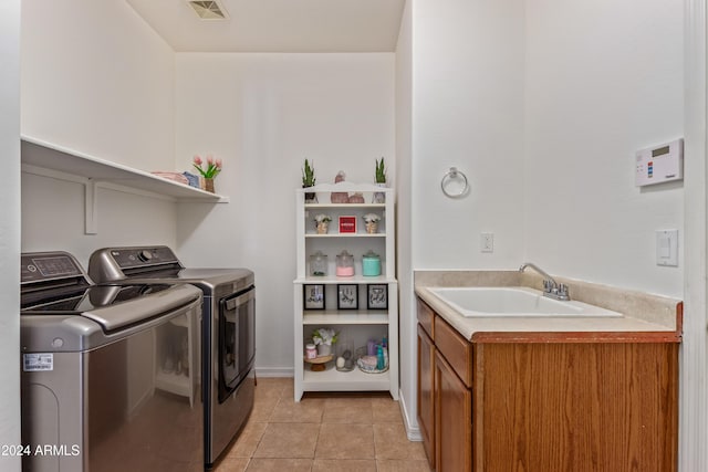 laundry area with cabinets, sink, light tile patterned flooring, and washer and dryer