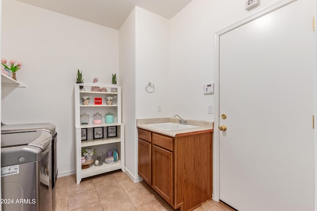 laundry area with sink, light tile patterned floors, and washer and dryer