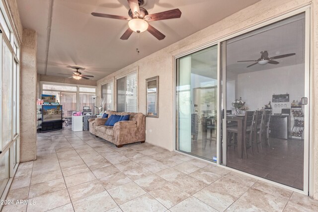 sunroom featuring ceiling fan and a healthy amount of sunlight