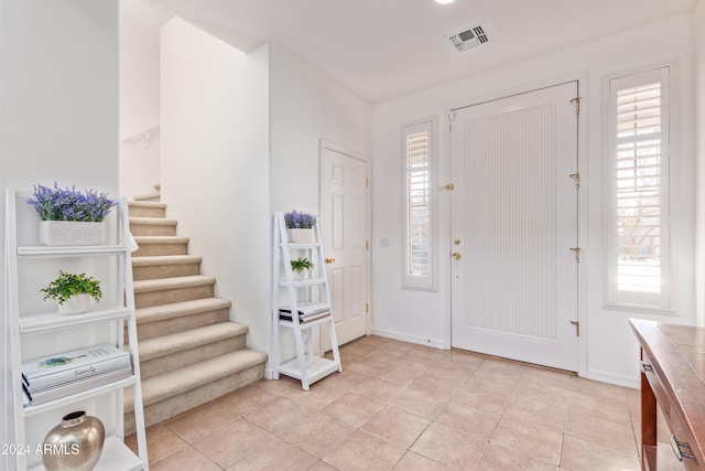 foyer entrance with light tile patterned floors and plenty of natural light