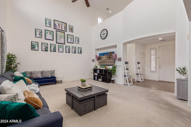 carpeted living room featuring high vaulted ceiling and ceiling fan