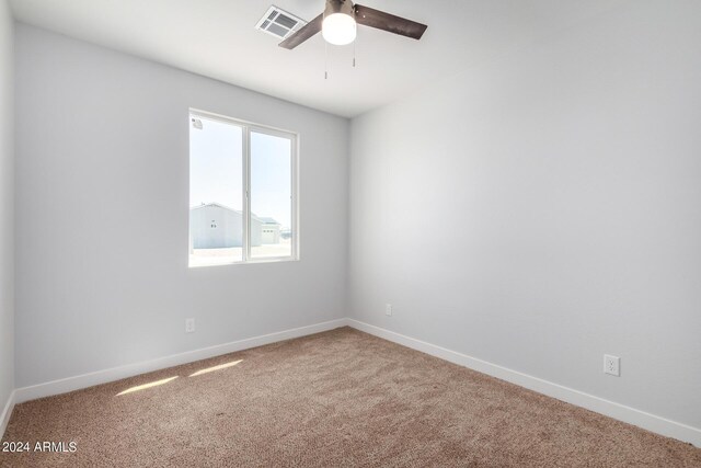 10785 W Arivaca Dr, Arizona City, AZ 85123 - spare room featuring carpet, visible vents, baseboards, and ceiling fan