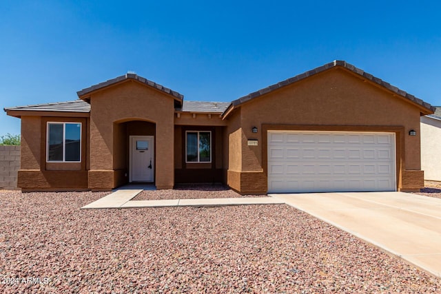 10785 W Arivaca Dr, Arizona City, AZ 85123 - view of front of home with a garage, driveway, stucco siding, and a tiled roof