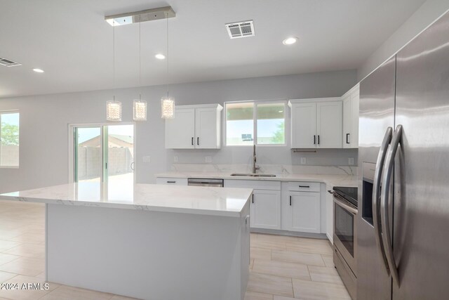 10785 W Arivaca Dr, Arizona City, AZ 85123 - kitchen with visible vents, a center island, a sink, appliances with stainless steel finishes, and white cabinetry