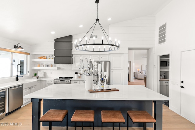 kitchen featuring a breakfast bar, pendant lighting, a center island, stainless steel appliances, and light stone countertops