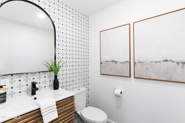 bathroom with vanity, tasteful backsplash, and toilet