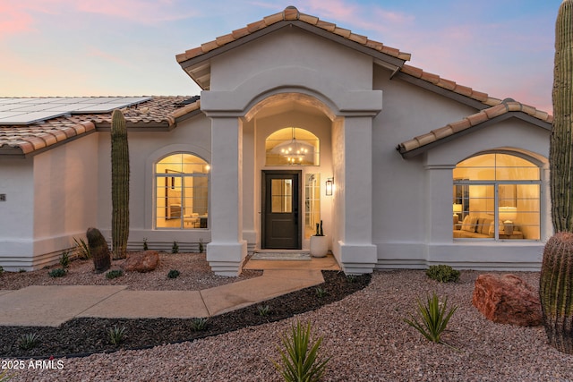 exterior entry at dusk featuring solar panels