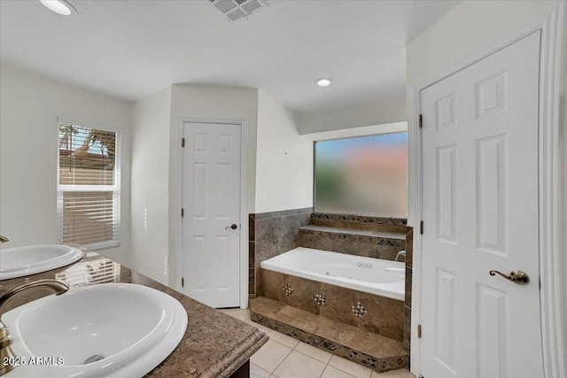 bathroom featuring vanity, tiled bath, and tile patterned flooring