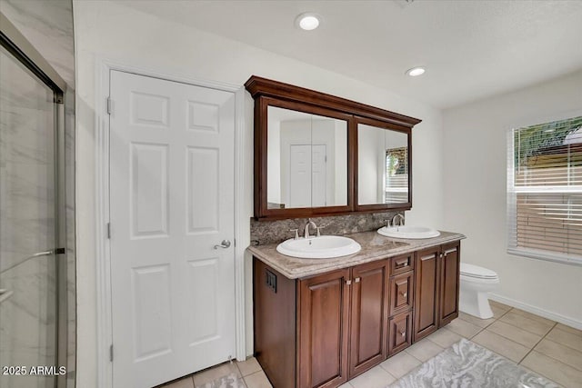 bathroom featuring vanity, plenty of natural light, a shower with shower door, and toilet