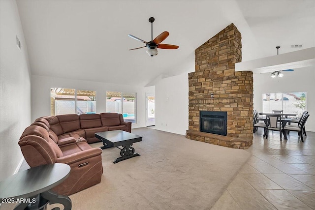 living room featuring ceiling fan, a fireplace, high vaulted ceiling, and a wealth of natural light