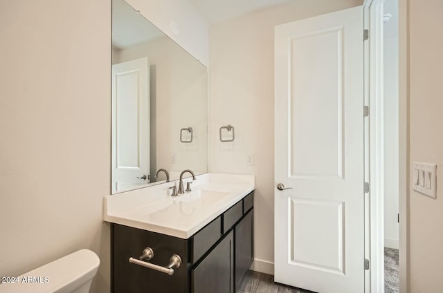 bathroom with vanity, hardwood / wood-style flooring, and toilet