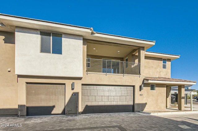 view of front of home featuring a garage and a balcony