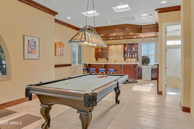 recreation room with light hardwood / wood-style floors, ornamental molding, pool table, and indoor bar