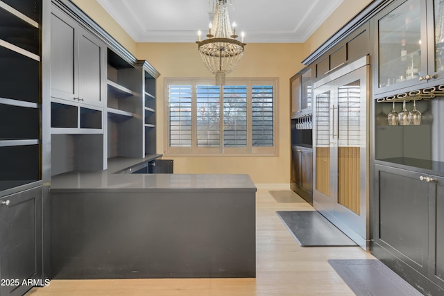 office with light hardwood / wood-style flooring, crown molding, and an inviting chandelier