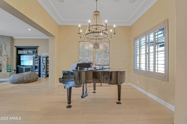 misc room with hardwood / wood-style flooring, a large fireplace, a notable chandelier, and ornamental molding