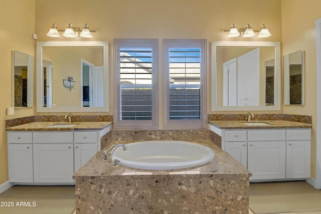 bathroom featuring vanity and a relaxing tiled tub