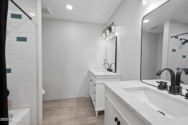 full bathroom with vanity, toilet, and tiled shower / bath combo