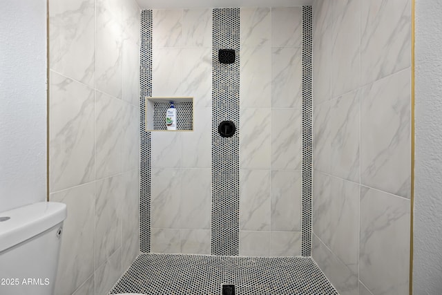 bathroom with tiled shower and toilet