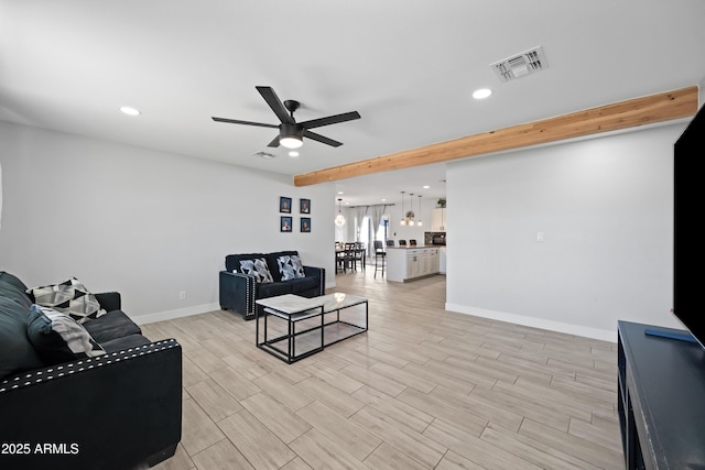 living room featuring ceiling fan and beamed ceiling