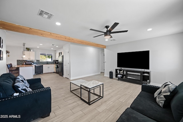 living room with beamed ceiling and ceiling fan