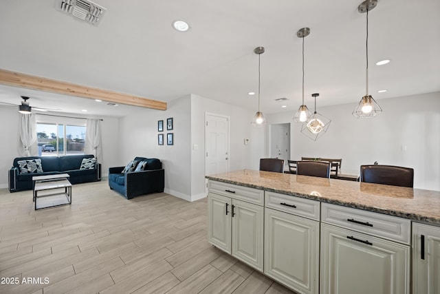 kitchen with pendant lighting, ceiling fan, light stone countertops, and beamed ceiling