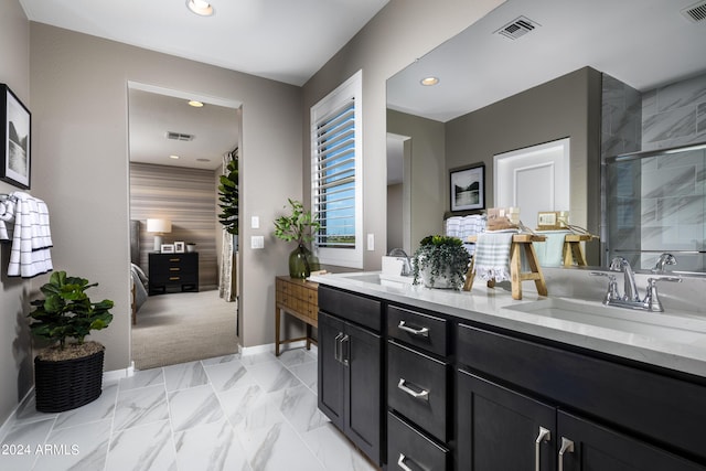 bathroom featuring double vanity, tiled shower, visible vents, and a sink