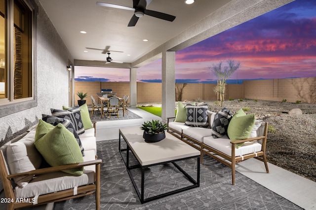 patio terrace at dusk featuring ceiling fan, outdoor lounge area, outdoor dining area, and a fenced backyard