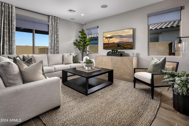 living room with recessed lighting, visible vents, and wood finished floors