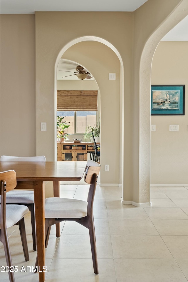 tiled dining space featuring ceiling fan