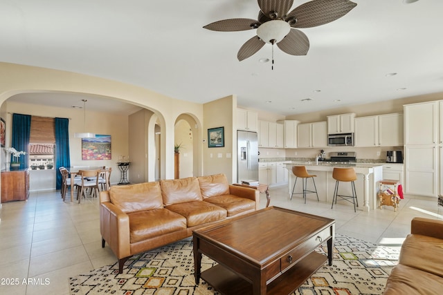 tiled living room with ceiling fan