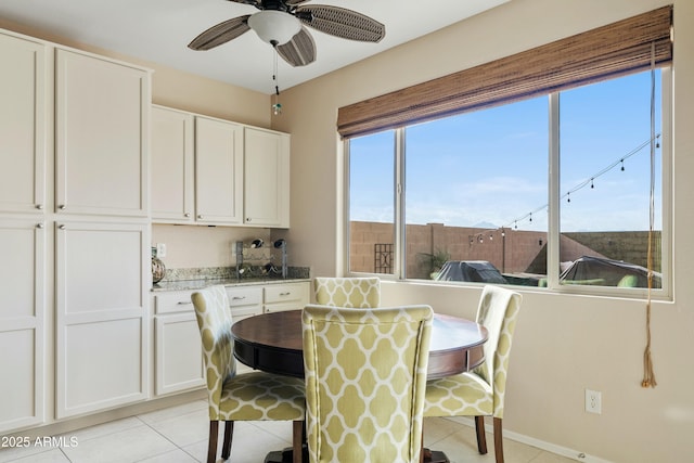 dining space featuring ceiling fan and light tile patterned floors