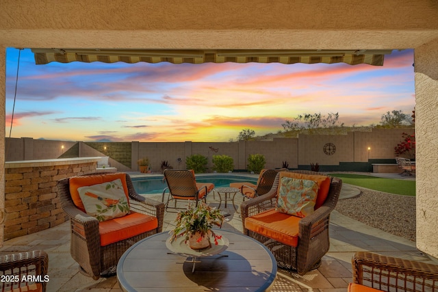 patio terrace at dusk with a fenced in pool