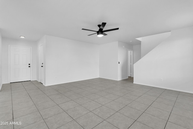 tiled spare room featuring ceiling fan