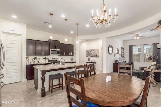 tiled dining area with ceiling fan with notable chandelier