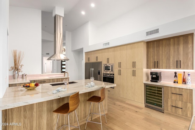 kitchen featuring light stone counters, wine cooler, a breakfast bar area, visible vents, and appliances with stainless steel finishes