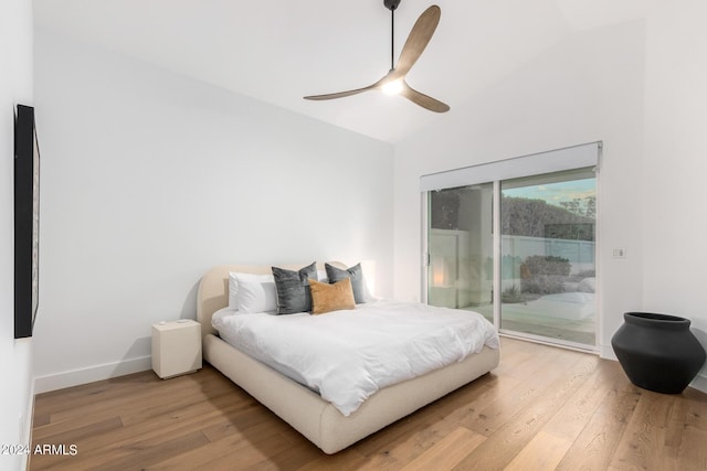 bedroom featuring light wood-style floors, access to outside, baseboards, and vaulted ceiling