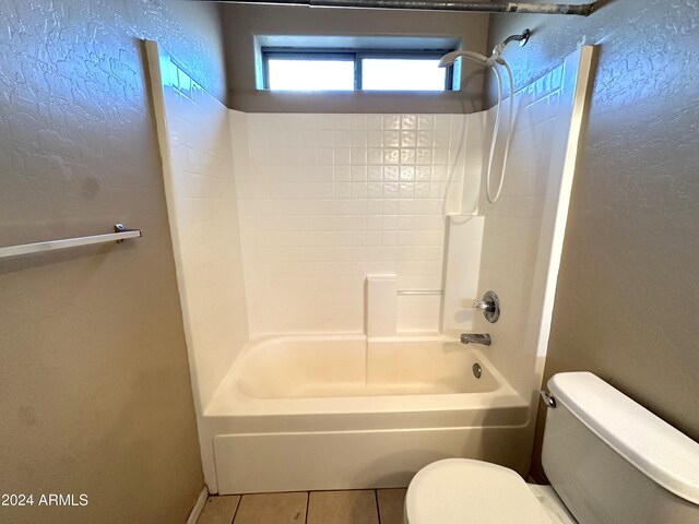 bathroom featuring toilet, shower / washtub combination, and tile patterned flooring