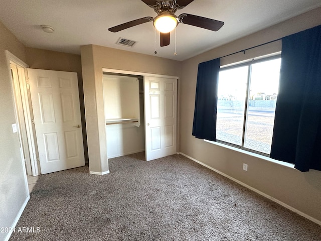 unfurnished bedroom featuring ceiling fan, a closet, and carpet flooring