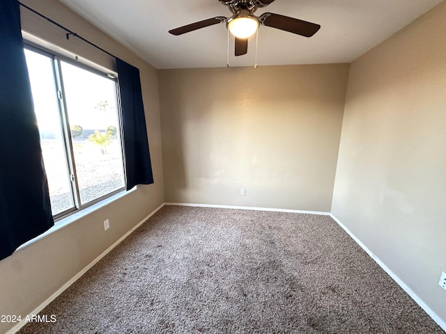 carpeted spare room featuring ceiling fan