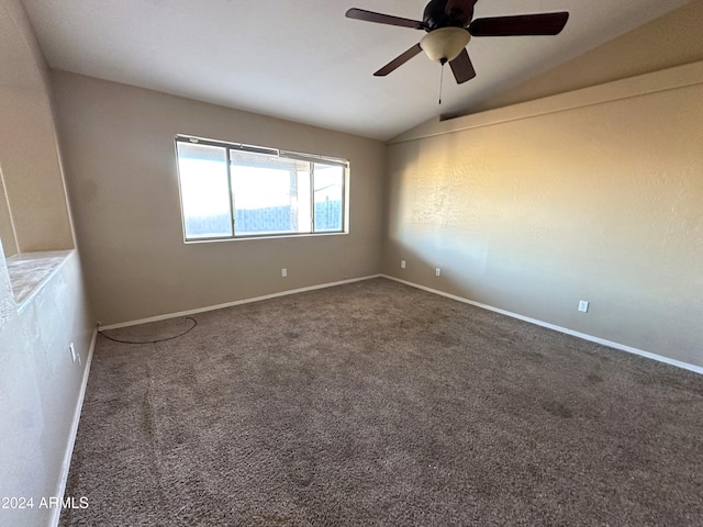 carpeted spare room featuring ceiling fan and vaulted ceiling