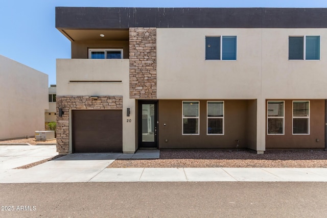 2000 N 36th St Unit 20, Phoenix, AZ 85008 - view of front facade with stucco siding, a garage, concrete driveway, and stone siding