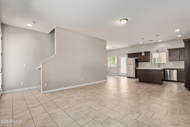 2000 N 36th St Unit 20, Phoenix, AZ 85008 - kitchen featuring stainless steel appliances, dark brown cabinetry, recessed lighting, open floor plan, and light countertops