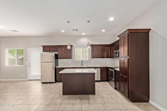 2000 N 36th St Unit 20, Phoenix, AZ 85008 - kitchen featuring appliances with stainless steel finishes, a center island, light countertops, decorative light fixtures, and light tile patterned floors
