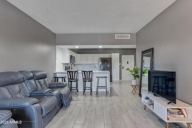 living room with sink and light hardwood / wood-style floors